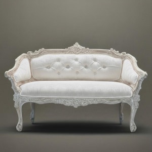 May include: A white, ornate loveseat with a tufted back and seat. The wooden frame is intricately carved and painted in a cream color. The sofa has curved legs and armrests, and is set against a neutral background.
