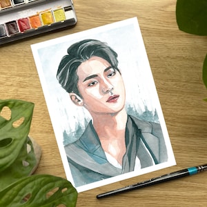 Peut inclure: Peinture à l'aquarelle d'une personne aux cheveux foncés sur un fond bleu clair. La personne porte une veste gris foncé et a une expression sérieuse.