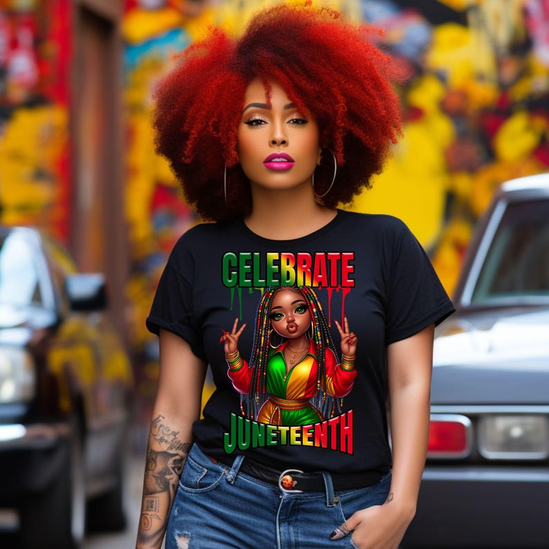 May include: Black t-shirt with the words "CELEBRATE JUNETEENTH" in green and red. The shirt features an illustration of a girl with braids, wearing a red, green, and yellow outfit, making a peace sign. The model has red hair and is wearing hoop earrings.