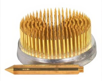 May include: A gold floral foam with a round base and a large number of sharp, gold-colored pins. The foam is used for arranging flowers and comes with a separate, gold-colored tool.