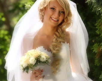 May include: A bride wearing a white wedding dress and veil, holding a bouquet of white flowers. She has her hair styled in a braid and is smiling.
