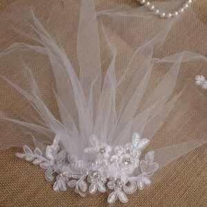 Peut inclure: Voile de mari&eacute;e blanche avec une d&eacute;licate bordure en dentelle et des embellissements en perles. Le voile est fait de tulle doux et est parfait pour un mariage ou une occasion sp&eacute;ciale.