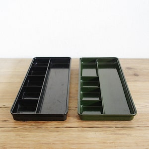 Op de afbeelding: Twee lange, rechthoekige trays met verdelers. Eén tray is zwart en de andere is groen.