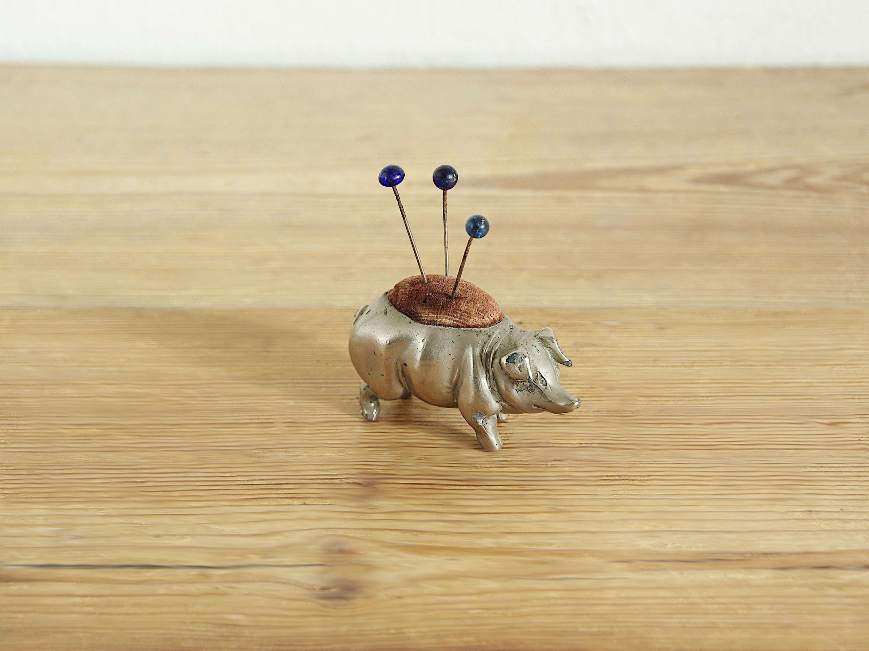 ガラスのヘッドピンが付いたヴィンテージアンティークピューター製豚の