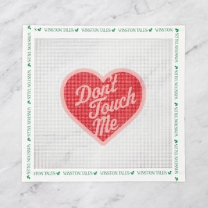 May include: A white canvas with a pink heart with the text "Don't Touch Me" in red lettering. The canvas is surrounded by a green border with the text "Winston Tales" repeated.