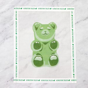May include: Green gummy bear with closed eyes and a smile. The gummy bear is in a standing position with its arms and legs outstretched.