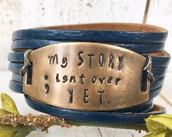 Metal Stamped Bronze Shield 'My Story Isn't Over Yet' Navy Blue Shredded Leather Double Wrap Adjustable  Bracelet
