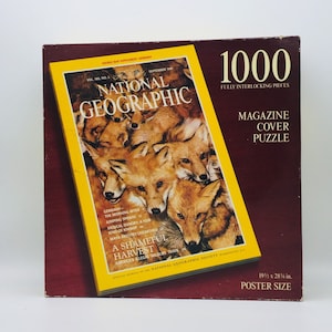 May include: A 1000-piece jigsaw puzzle featuring the September 1991 cover of National Geographic magazine. The cover image shows a group of red foxes huddled together. The text on the cover reads "A Shameful Harvest: America's Illegal Wildlife Trade".