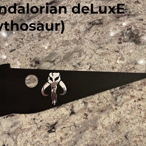 May include: Black Mandalorian deLuxE (mythosaur) metal sign with a silver Mandalorian symbol.
