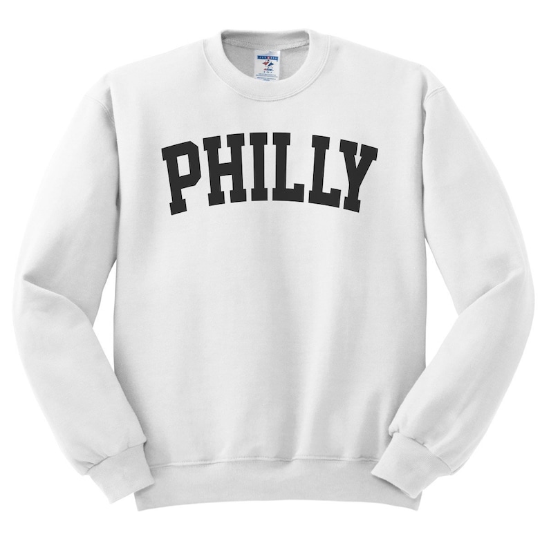 Puede incluir: Sudadera blanca con texto negro que dice "PHILLY" en una fuente arqueada.
