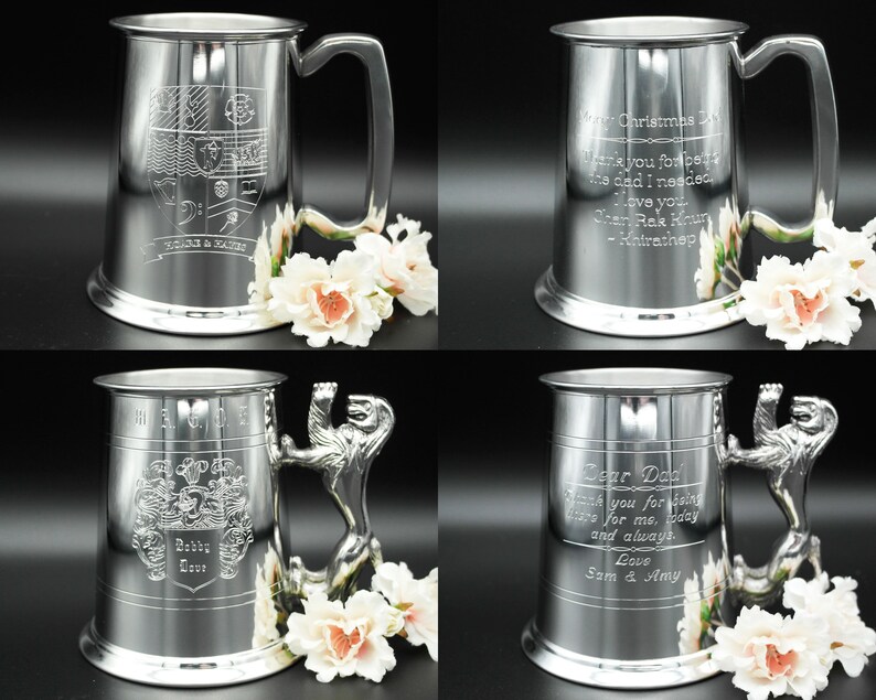 May include: Four silver pewter tankards with different engravings. The tankards have a lion head handle and a rounded base. The engravings include a coat of arms, a Christmas message, and a message to a father.