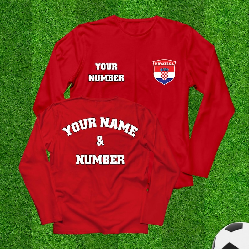 May include: Two red long-sleeve shirts with white text and a Croatian flag emblem. One shirt displays "YOUR NUMBER" and the other says "YOUR NAME & NUMBER". The shirts are on a green background, suggesting a sports theme.