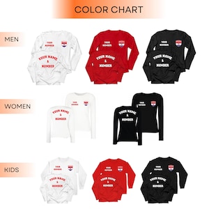 May include: A color chart displays long-sleeved shirts in white, red, and black. The shirts are available in men's, women's, and kids' sizes. Each shirt features a small emblem and the option to customize with a name and number.