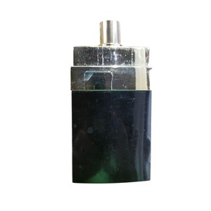 Puede incluir: Un frasco de perfume rectangular negro con una tapa plateada y un pulverizador dorado. El frasco tiene un dise&ntilde;o elegante y moderno, y la tapa est&aacute; ligeramente deslustrada.