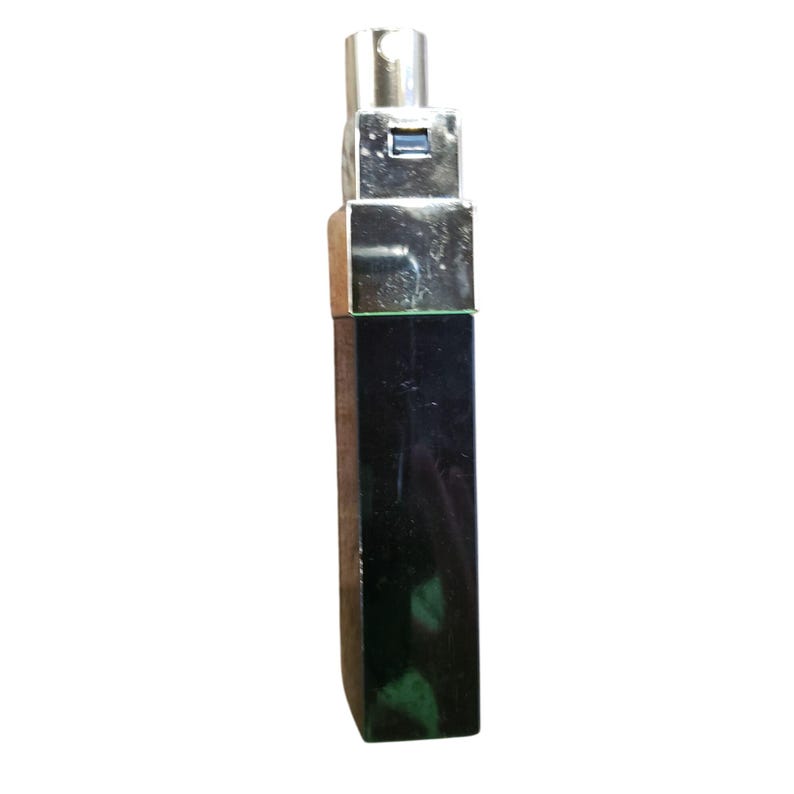 Puede incluir: Un frasco de perfume rectangular negro con una parte superior met&aacute;lica plateada. El frasco tiene un dise&ntilde;o elegante y moderno, con un pulverizador plateado. El frasco est&aacute; de pie sobre un fondo blanco.