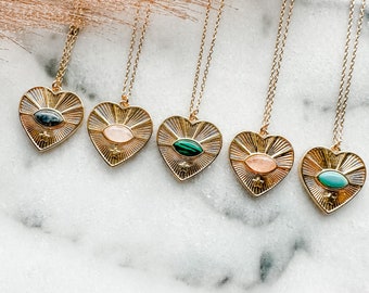 May include: Five gold heart-shaped necklaces with different colored gemstone eyes. Each necklace features a star charm and a delicate chain.