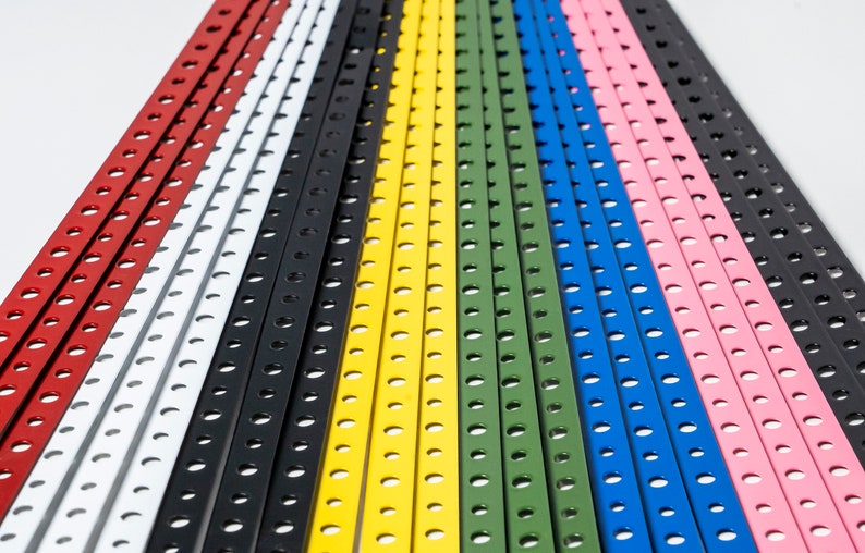 May include: A collection of colorful metal strips with evenly spaced holes. The strips are arranged in a rainbow pattern, with red, white, black, yellow, green, blue, and pink.