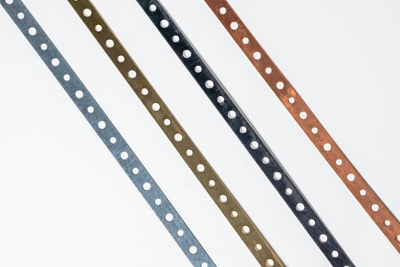 May include: Four metal strips with evenly spaced holes, arranged diagonally. The strips are silver, gold, black, and copper.