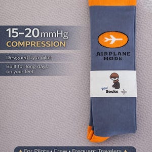 May include: Blue compression socks with orange accents, featuring an airplane graphic and the words "AIRPLANE MODE." Text on the socks reads "15-20 mmHg COMPRESSION" and "Designed by a pilot." The socks are designed for pilots, crew, and frequent travelers.
