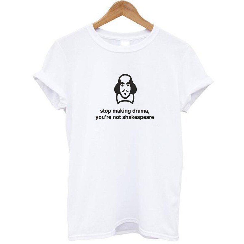 May include: White t-shirt with a black graphic of William Shakespeare's face and the text "stop making drama, you're not Shakespeare".