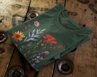 May include: A green t-shirt with a floral print featuring a variety of flowers in shades of red, orange, yellow, purple, and blue.
