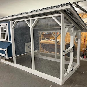May include: A white and blue chicken coop with a metal roof and a wire mesh enclosure. The coop has a nesting box and a door with a latch.
