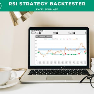 May include: A laptop computer displaying a chart with a line graph and data points. The chart is titled "RSI Technical Indicator" and shows the close price, RSI, and buy and sell signals. The laptop is on a white surface with a cup of coffee and a pair of glasses.
