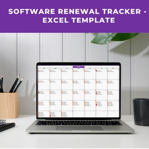 May include: A laptop computer displaying a spreadsheet with a calendar view. The spreadsheet is titled "Software Renewal Tracker - Excel Template". The laptop is on a white desk with a cup of coffee, a pencil holder, and a stack of notebooks.