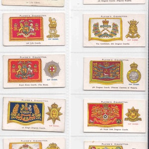 Könnte beinhalten: Eine Sammlung von zehn Vintage-Zigarettenkarten mit den Regimentsabzeichen britischer Armeeregimenter. Jede Karte zeigt eine farbenfrohe Illustration des Regimentsabzeichens und ein kleines Bild des Mützenabzeichens. Die Karten sind auf weißem Papier mit schwarzem Rand gedruckt.