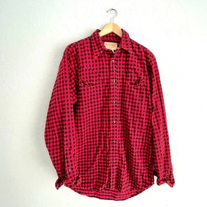 Op de afbeelding: Rood en zwart geruit flanellen overhemd met lange mouwen en een knoopsluiting.