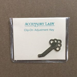 May include: A silver-toned clip-on adjustment key packaged in a clear plastic bag with a white card that reads "Accessory Lady Clip-On Adjustment Key".