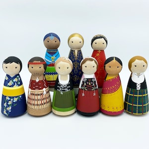 May include: Nine wooden peg dolls dressed in colorful traditional clothing from around the world. The dolls are painted with intricate details and stand on a white background.