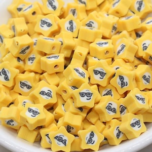 May include: A bowl filled with yellow star-shaped beads with black and white smiley faces wearing sunglasses.