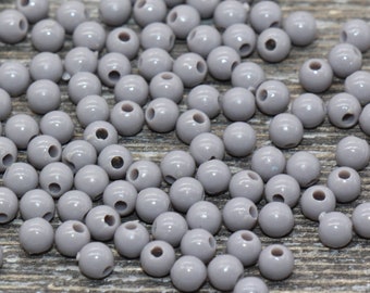 Peut inclure: Un tas de perles en plastique grises, parfaites pour les projets d'artisanat.