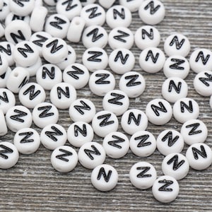 May include: A large quantity of white plastic letter beads with the letter "Z" printed in black.