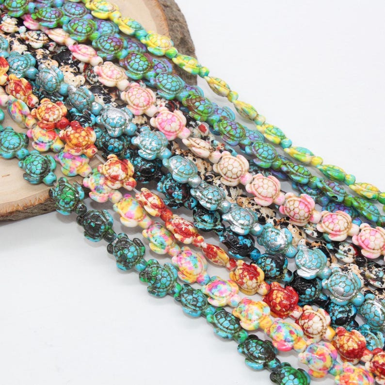 May include: A strand of colorful turtle-shaped beads. The beads are made of a white material with a variety of colors and patterns. The beads are strung on a clear elastic cord.