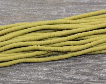May include: A strand of olive green clay beads, each bead is a flat disc with a hole in the center. The beads are stacked on top of each other, creating a layered effect.