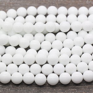 Peut inclure: Un brin de perles rondes blanches en jade blanc poli. Les perles sont lisses et brillantes.