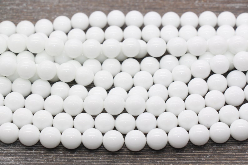 Peut inclure: Un brin de perles rondes blanches en jade blanc poli. Les perles sont lisses et brillantes.