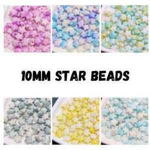 May include: A collection of star-shaped beads in various colors, including pink, blue, yellow, and green. The beads are 10mm in size and are displayed in small white trays. The text "10MM STAR BEADS" is displayed in bold, black letters.