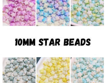 May include: A collection of star-shaped beads in various colors, including pink, blue, yellow, and green. The beads are 10mm in size and are displayed in small white trays. The text "10MM STAR BEADS" is displayed in bold, black letters.