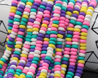 May include: A strand of colorful, round beads in shades of pink, yellow, white, purple, and turquoise. The beads are arranged in a repeating pattern.