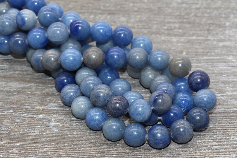 Pode incluir: Um fio de contas de pedra preciosa de quartzo azul. As contas redondas apresentam tons de azul e cinza. As contas s&atilde;o enfiadas, para um colar ou pulseira.