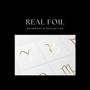 May include: Gold foil zodiac signs on white cards. The signs are Aries, Taurus, Gemini, Cancer, Leo, Virgo, Libra, Scorpio, Sagittarius, Capricorn, Aquarius, and Pisces.