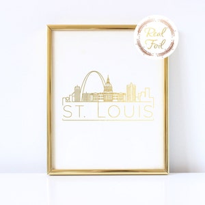 May include: Gold foil print of the St. Louis skyline with the Gateway Arch and the words "ST. LOUIS" in a gold frame.