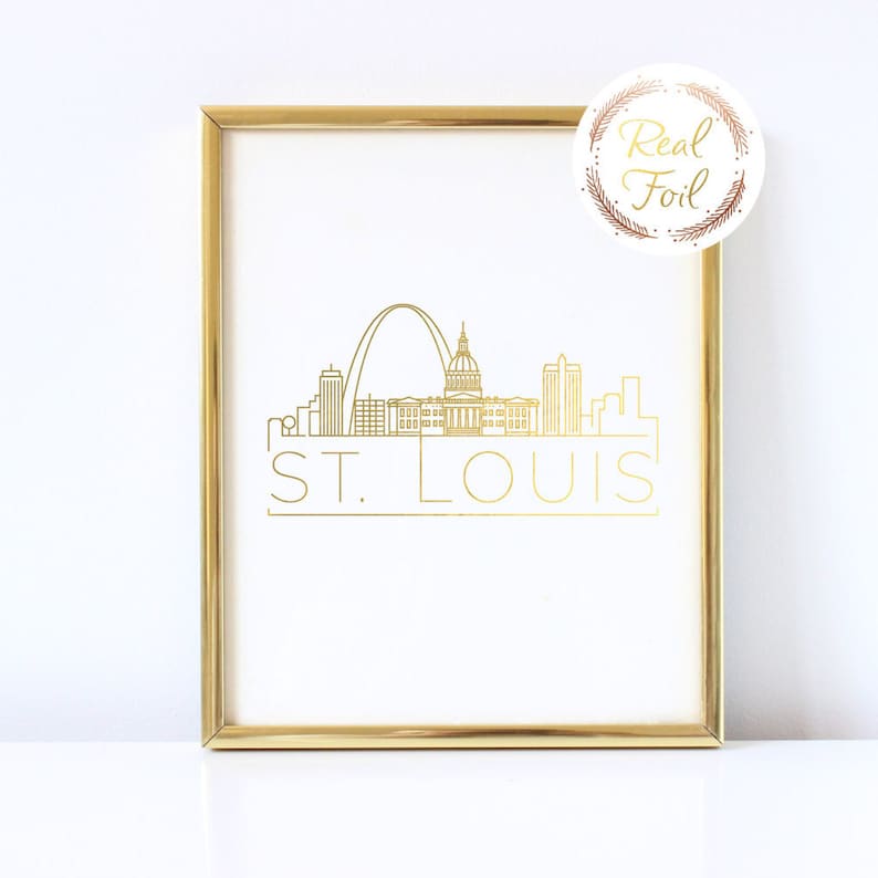 May include: Gold foil print of the St. Louis skyline with the Gateway Arch and the words "ST. LOUIS" in a gold frame.