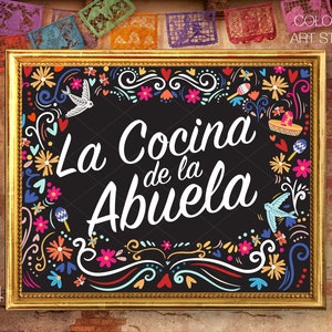 May include: A framed black chalkboard-style sign with the text "La Cocina de la Abuela" in white script, surrounded by colorful floral and decorative elements. The frame is gold, and the sign is 11x14 inches.