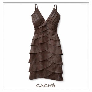 May include: Brown, layered dress with thin spaghetti straps and a V-neckline. The dress features a tiered skirt and a fitted bodice. The brand name "CACHÉ" is printed at the bottom of the image. The dress is made of a soft, textured material.