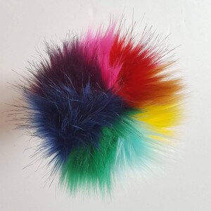 Puede incluir: Un pomp&oacute;n esponjoso y colorido con seis secciones de piel en diferentes colores: azul oscuro, verde, azul claro, amarillo, rojo y rosa.