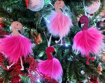 May include: Pink flamingo ornaments with fluffy feathers, perfect for decorating a Christmas tree. The ornaments are pink and white and have a festive look.